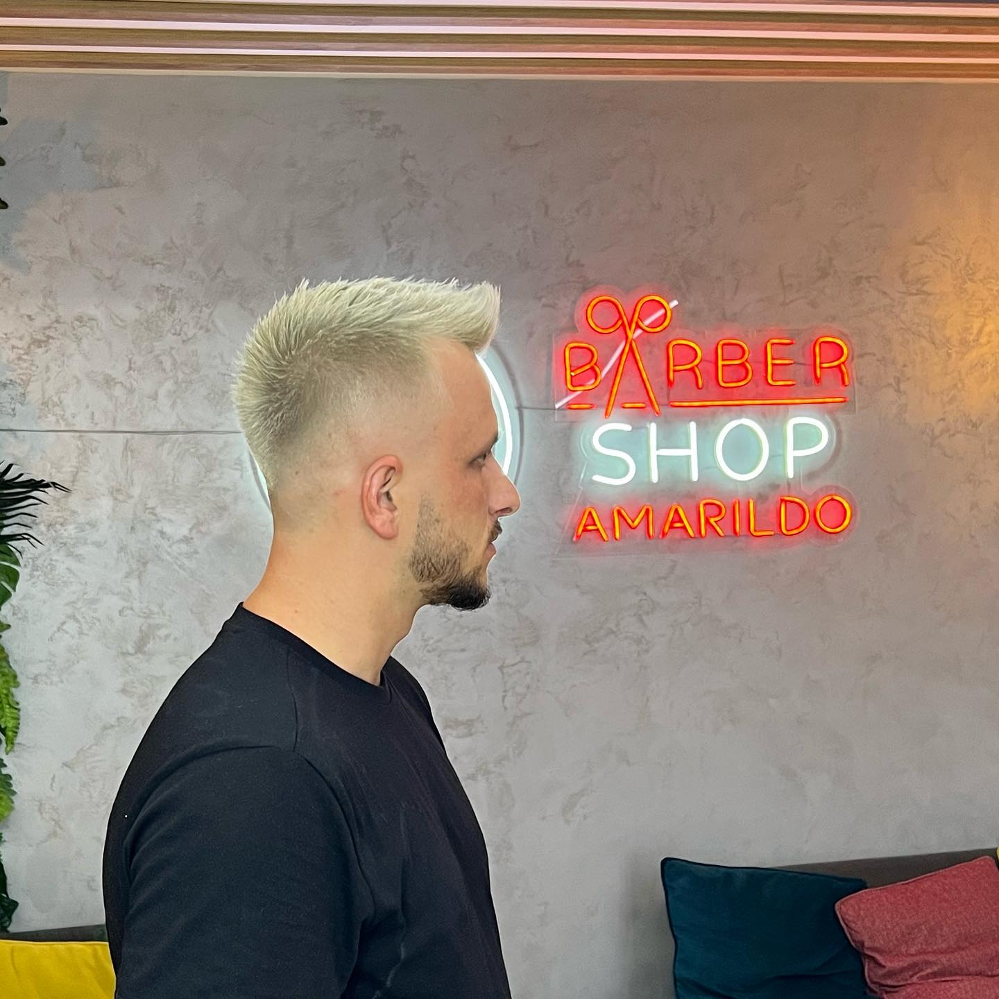 A fresh blond fade beside the neon BarberShop Amarildo sign